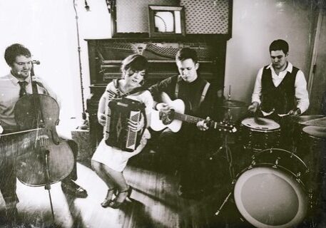 Band performing with accordion and acoustic instruments.
