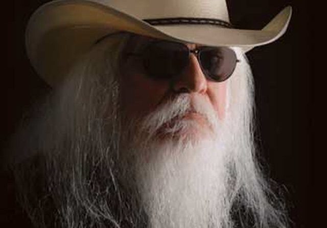 Man with long beard wearing cowboy hat.