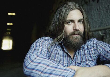 Man with long hair and beard, plaid shirt.
