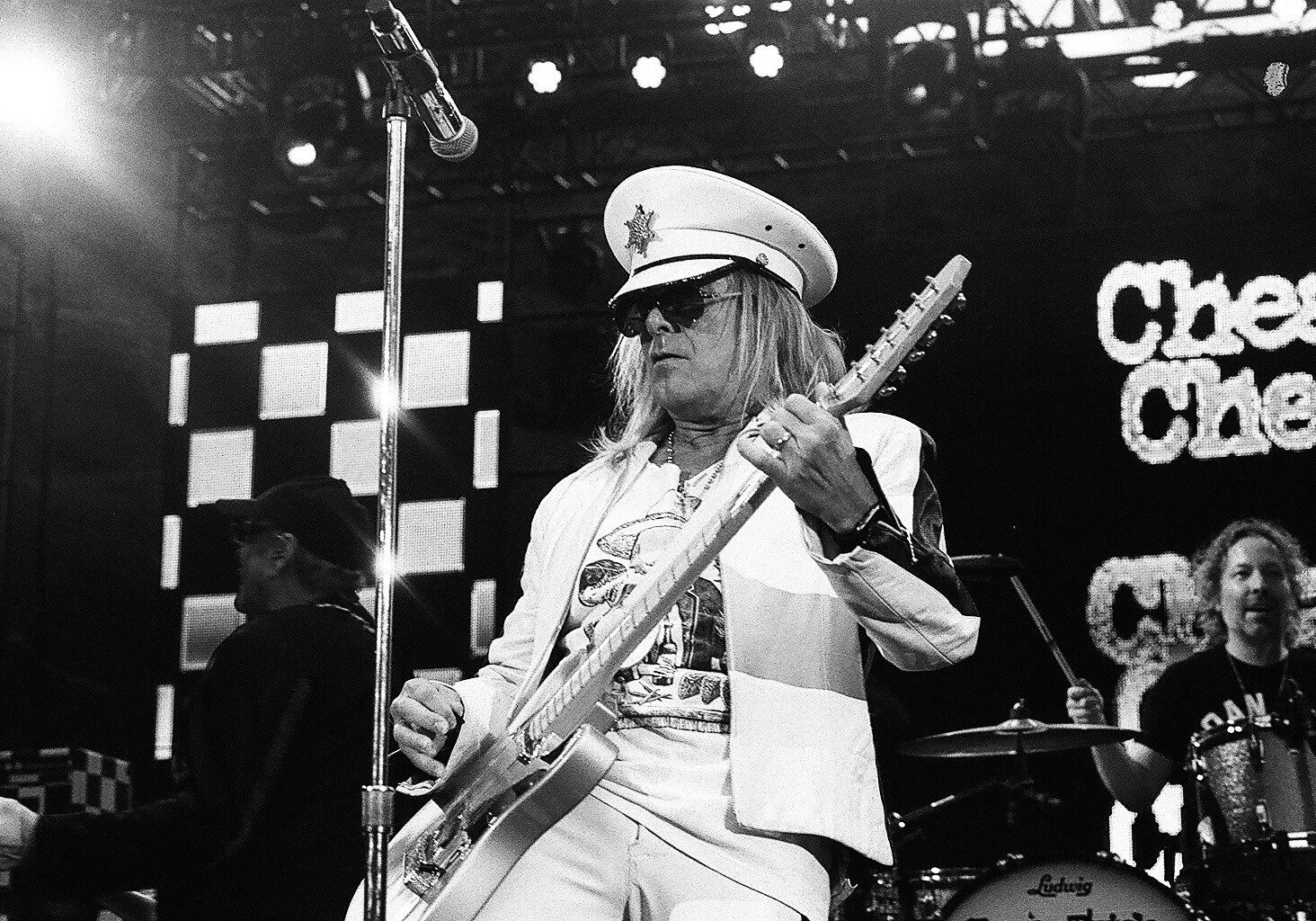 Guitarist performing on stage with band.