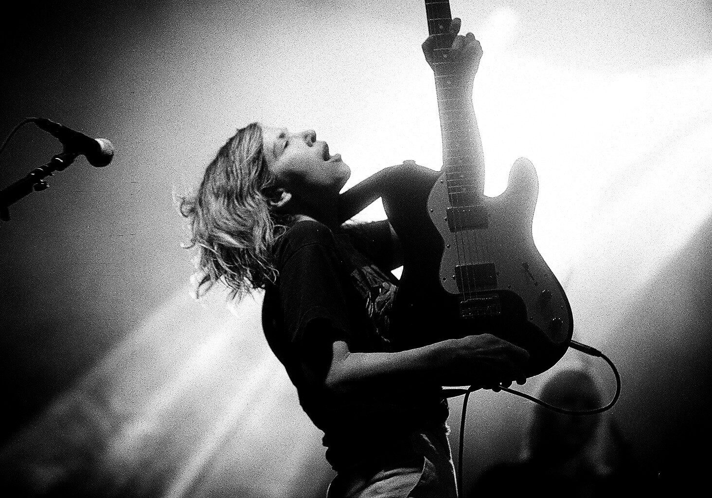 Musician passionately playing electric guitar on stage.