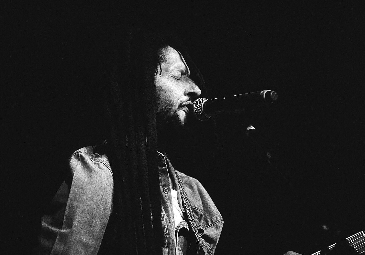 Singer performing with microphone on stage.
