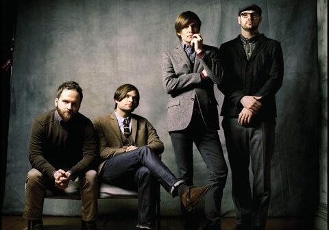 Four men posing in smart casual attire.
