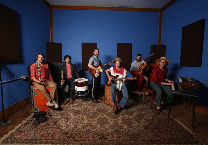 Band rehearsing in a blue music studio.