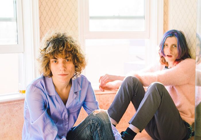 Two people sitting near a sunlit window.