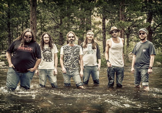 Band standing in a forest stream.