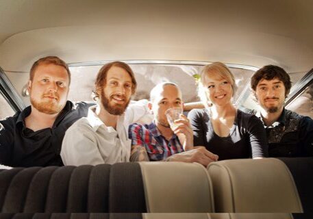 Five people sitting inside a car.