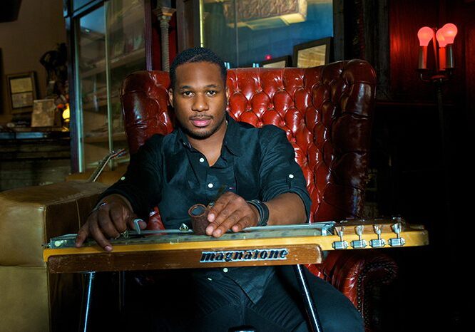 Musician seated with a lap steel guitar.