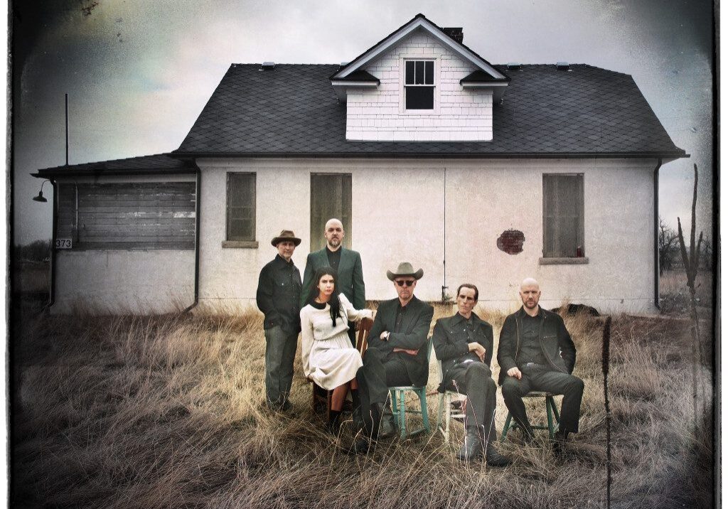 Group sitting outside an old rural house.