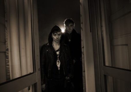 Two people standing in dimly lit doorway.