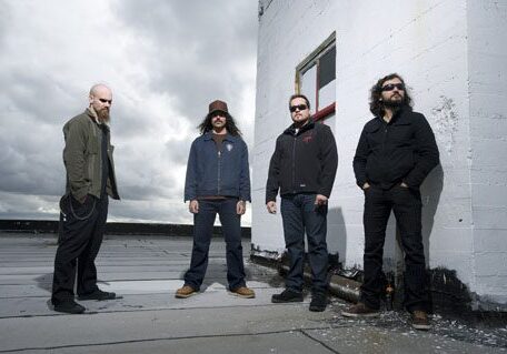 Four men standing on a rooftop.