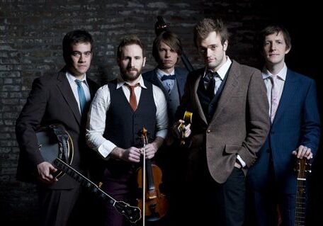 Five men posing with musical instruments.