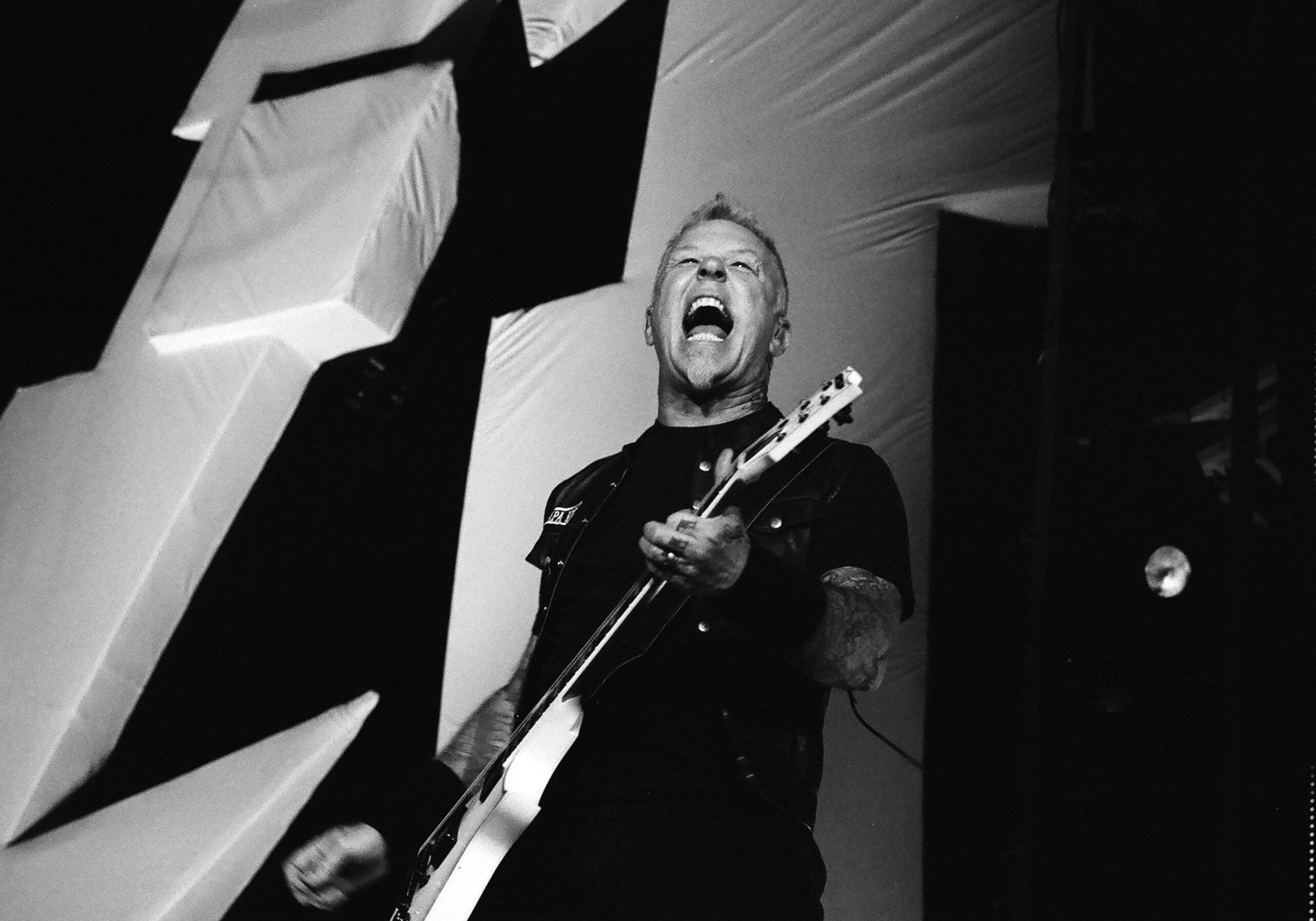 Musician passionately playing guitar on stage.