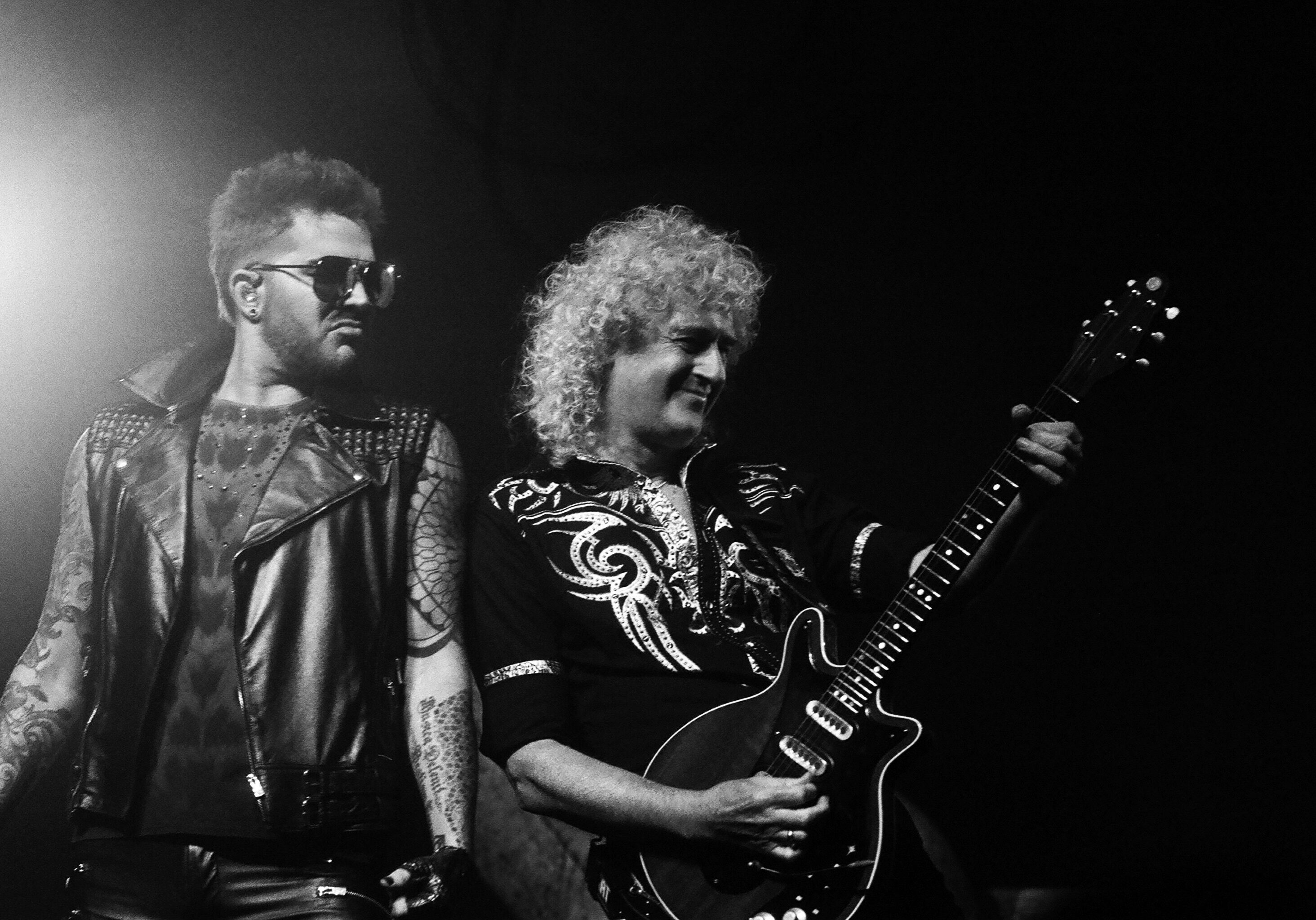 Two musicians performing on stage with guitars.