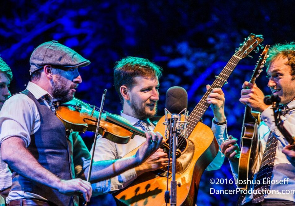Musicians performing with violins and guitar.