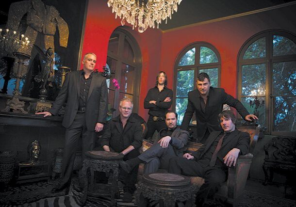 Group of six men in ornate room.