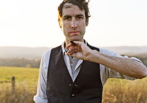 Man standing in field with vest.