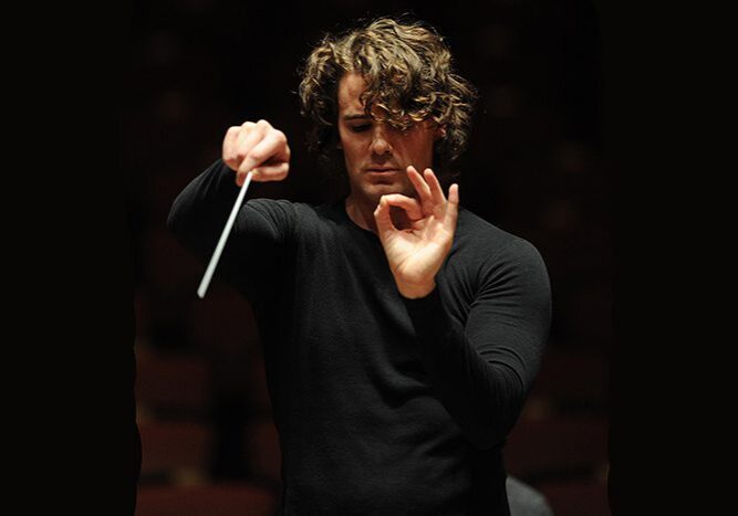 Conductor leading orchestra with baton.