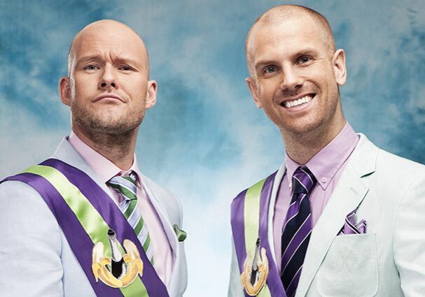 Two men in suits with colorful sashes.