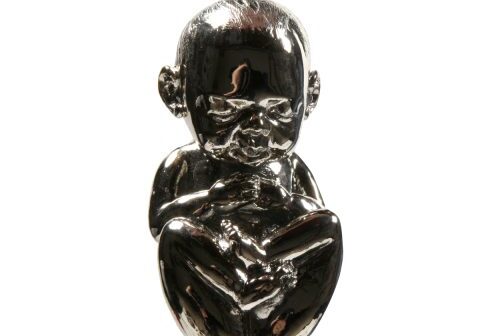 Chrome baby sculpture hanging by a chain.