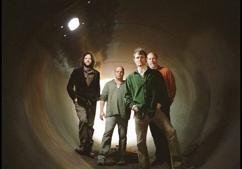 Four men standing inside a large tunnel.