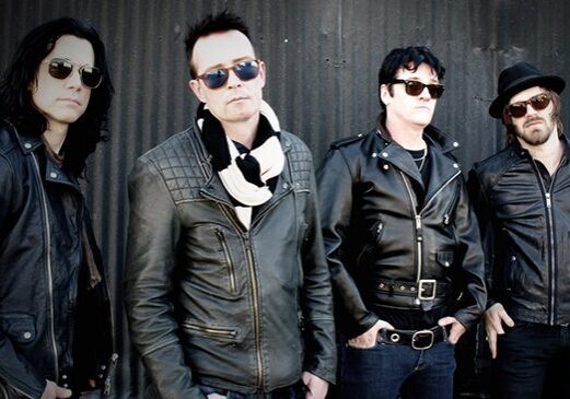 Four men in leather jackets and sunglasses.