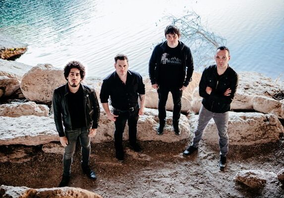 Four men standing on rocky terrain.