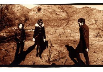 Four people standing in a barren landscape.