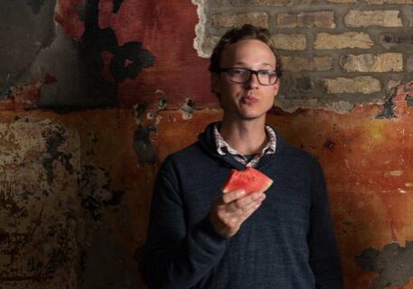 Man holding a slice of watermelon.