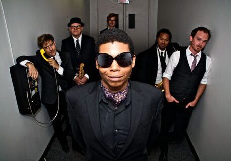 Group of six stylishly dressed musicians.