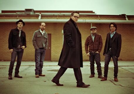 Five men standing in casual outdoor setting.
