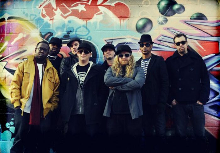 Group of people in front of graffiti.