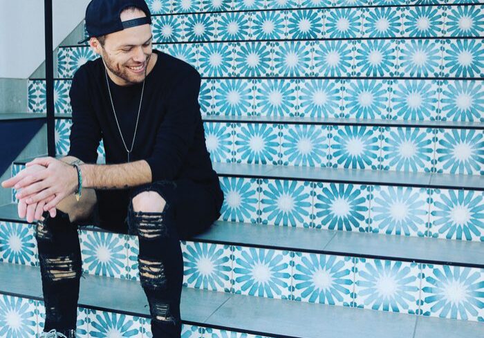 Man sitting on patterned tiled stairs.
