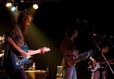 Band performing live on stage with guitars.
