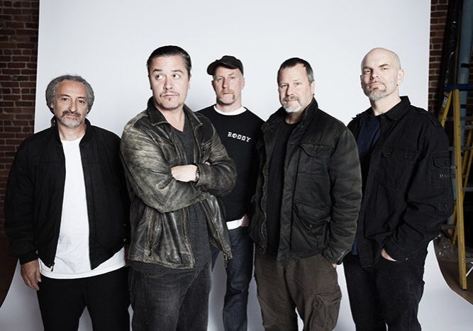 Five men posing against a white backdrop.