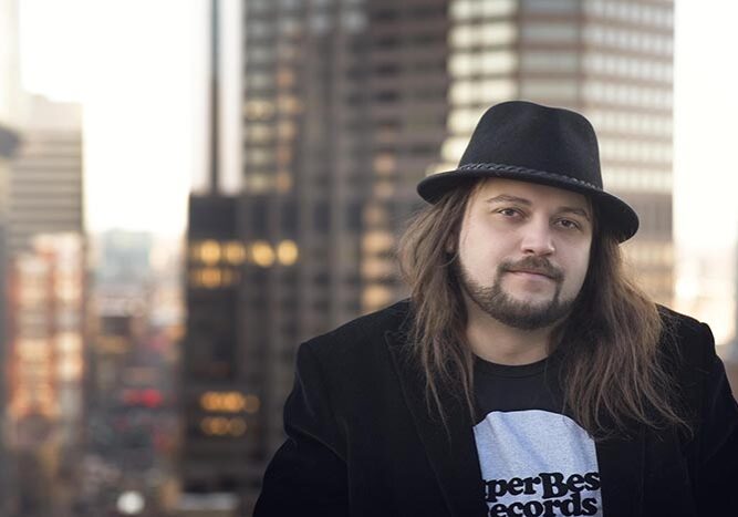 Man with hat in urban cityscape background.