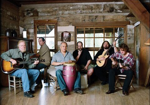 Band playing instruments in a rustic room.