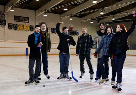 Group of people posing on ice rink.