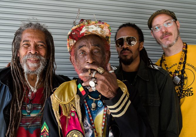Four men posing with colorful attire.