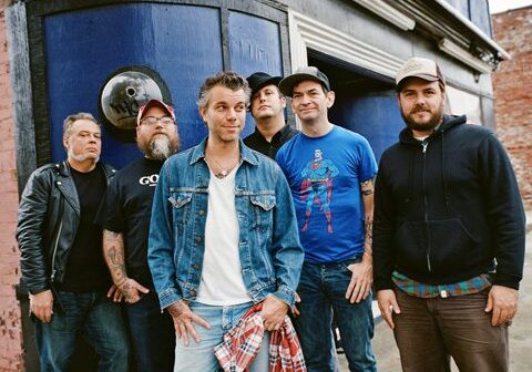 Group of six men standing outdoors.