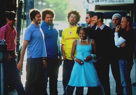 Group of people smiling outdoors on street.