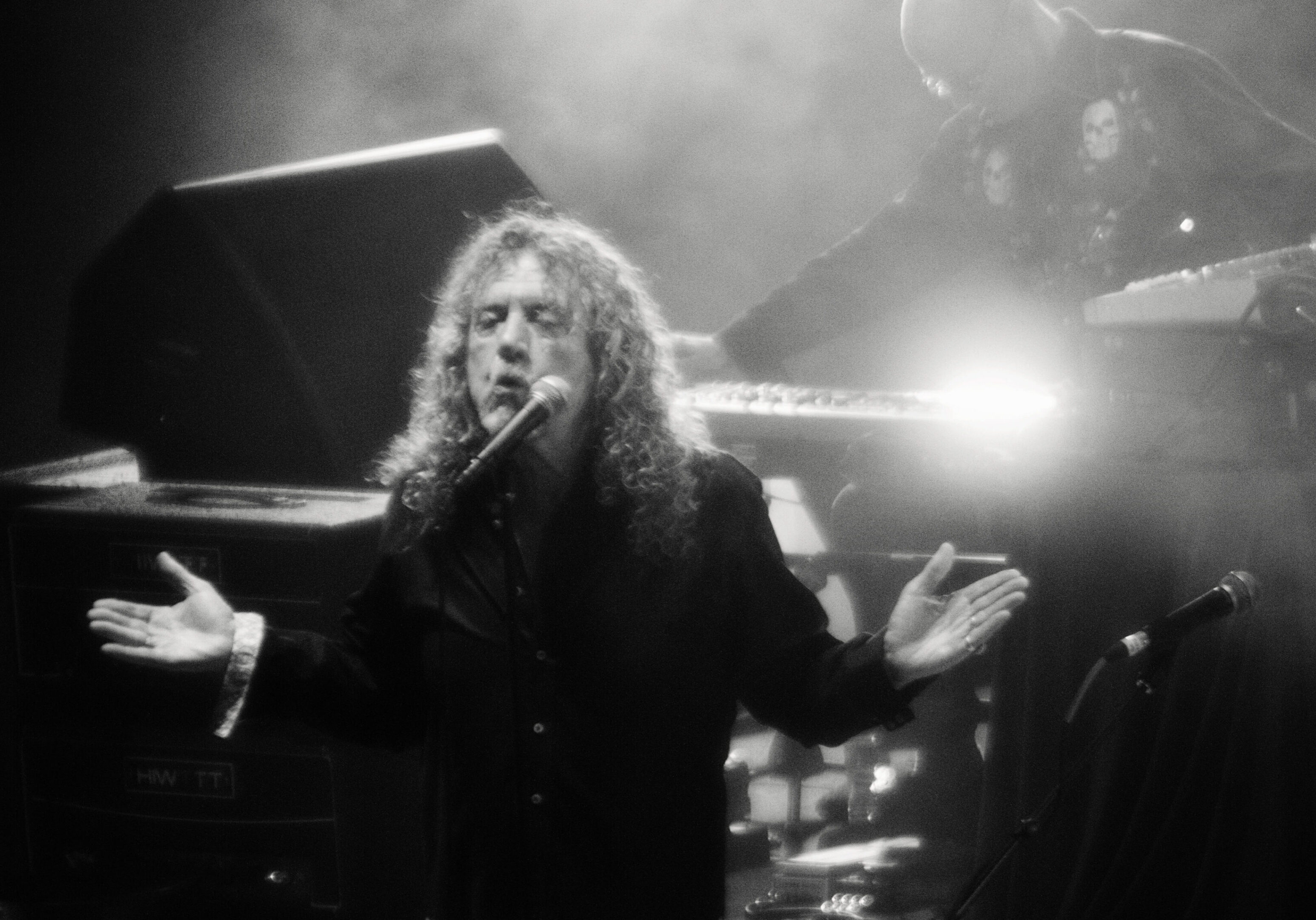 Singer performing on stage with keyboardist.