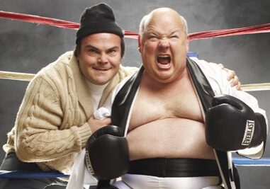 Two men posing in a boxing ring.