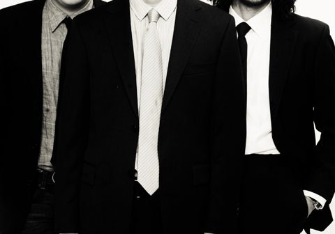 Three men in suits, black and white.