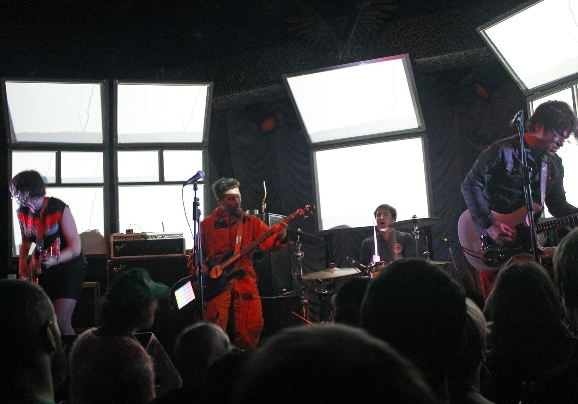 Band performing on stage in dim lighting.