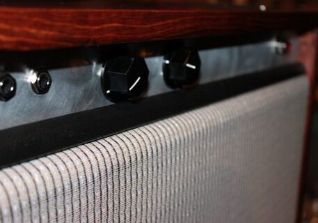 Guitar amplifier with control knobs and grille.