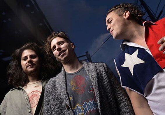 Three people standing under a dark sky.