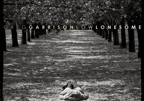 Person lying under trees in a grove.