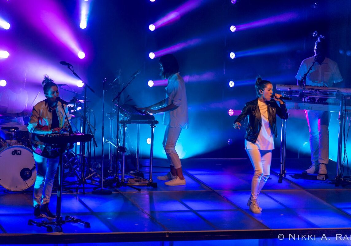 Band performing on stage with colorful lights.