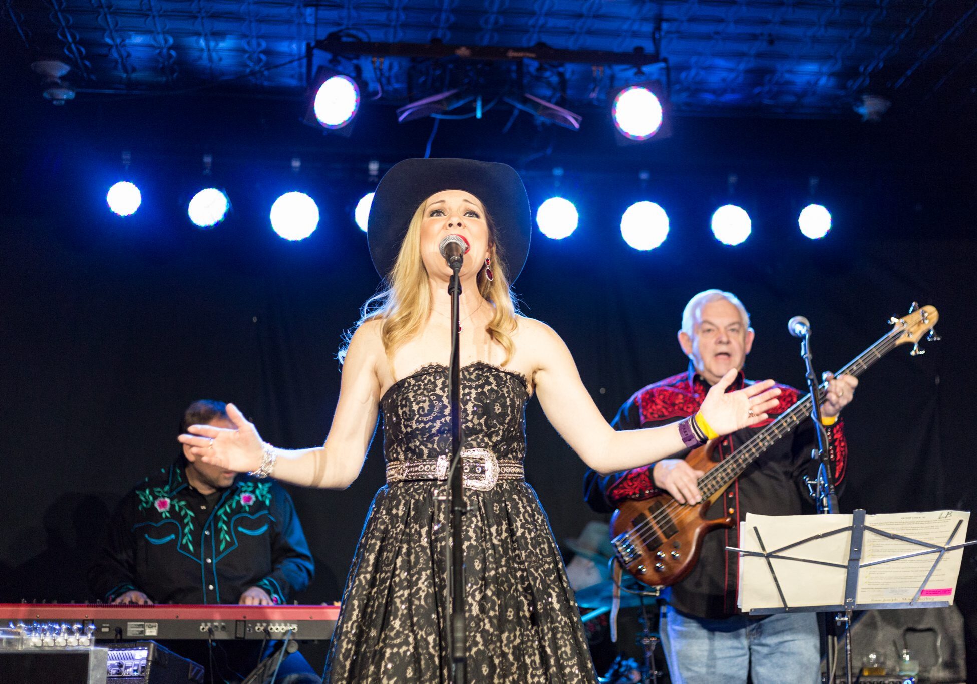 Singer performing on stage with band.